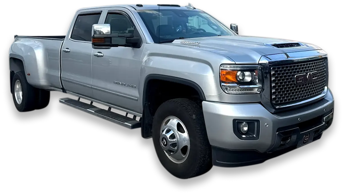 A silver GMC Sierra 3500HD Denali pickup truck, possibly a model from 2017 or 2018, is shown at an angle against a transparent background. The truck is a dually, featuring dual rear wheels, and has a crew cab. The Denali trim is indicated by the grille and other features.